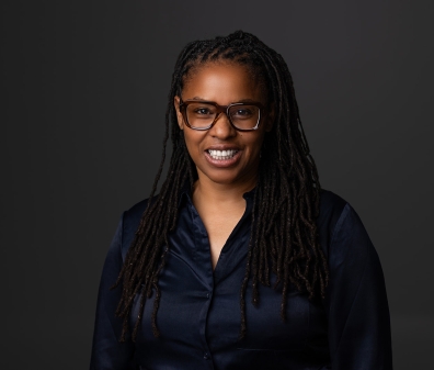 Headshot of a woman with glasses and a dark blue shirt