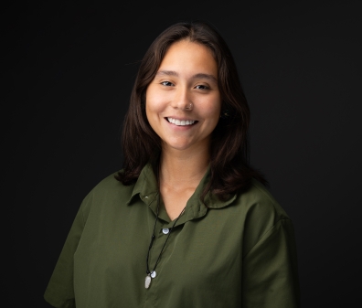 Headshot of a woman in a green button up and shoulder length brown hair